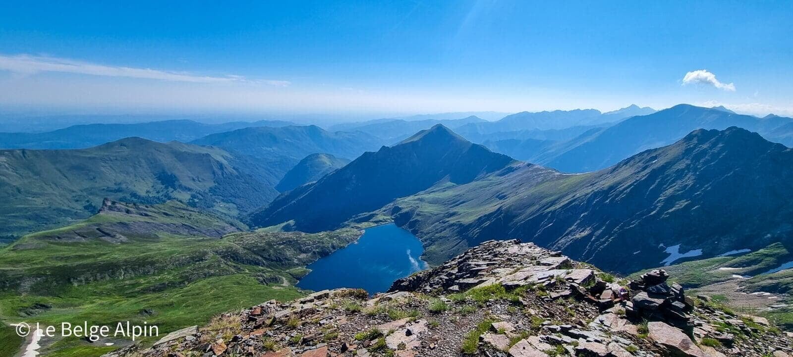 Panorama alpin : vue plongeante sur un lac de montagne cerné de sommets 3000+